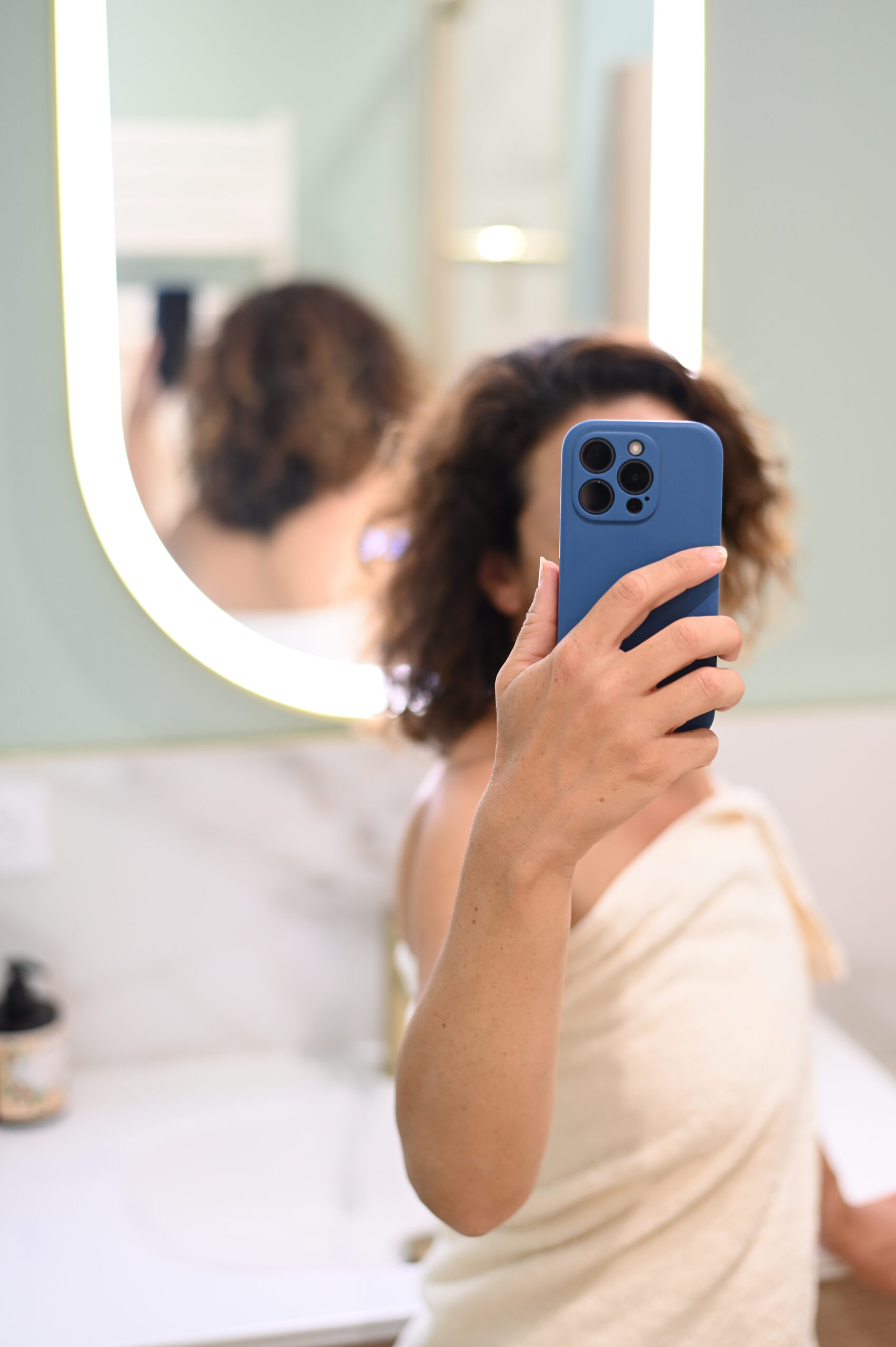 Kvinde tager spejlselfie med blå mobiltelefon