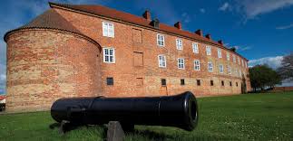 S&oslash;nderborg Slot med hvide mure og r&oslash;dt tag spejlet i Als Sund
